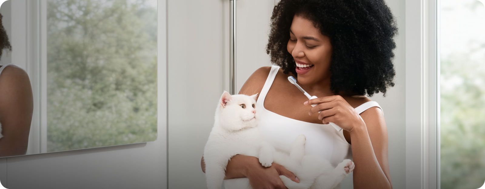 Woman brushing her teeth with a cat in a bathroom setting