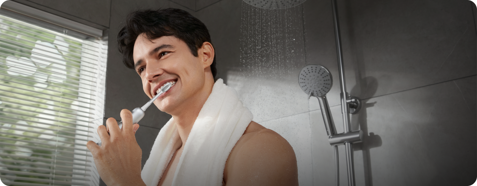 Man brushing his teeth in a shower with tiled walls.